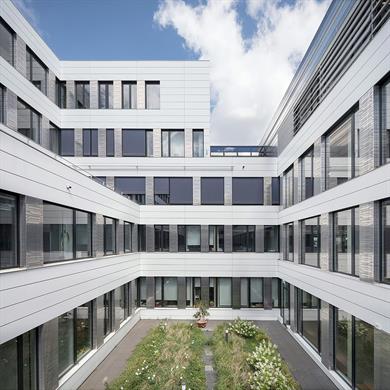 This picture shows building fife of the new campus Derendorf of Hochschule Düsseldorf. The front of the building is of glass and steel, indoors you see blue elements like the stairs and some walls. This building includes the Faculty of Electrical Engineering & Information Technology and the Faculty of Mechanical and Process Engineering.